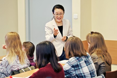 In the foreground, the lecturer with an interactive monitor in the background during the lesson. Click to zoom the picture.